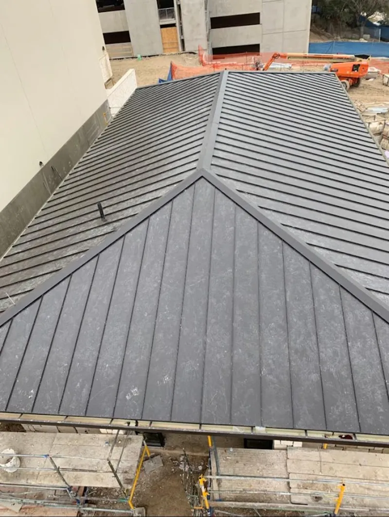 Commercial metal roof construction with crane equipment in Smithville